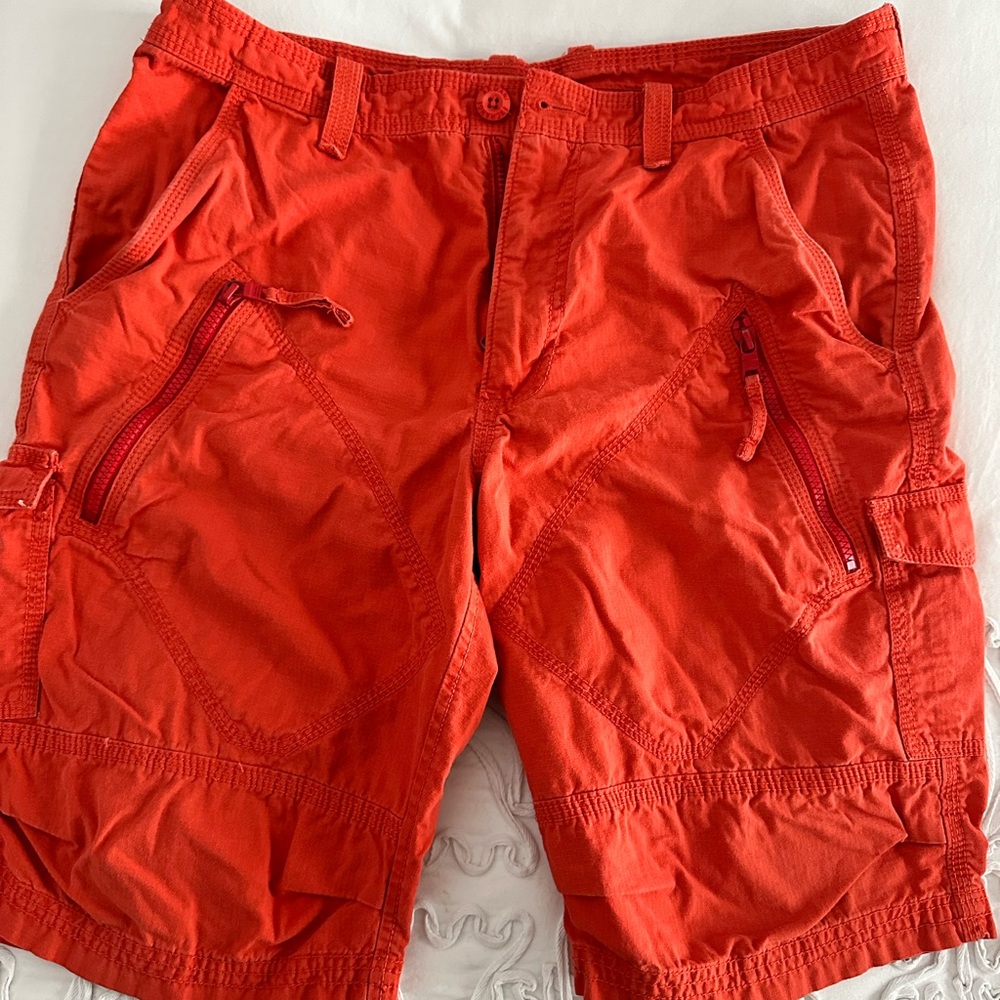 Distressed orange cargo shorts.